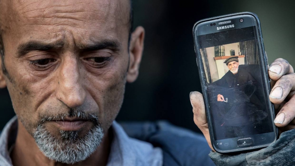 Omar Nabi holds a photo of his father, 71-year-old Haji-Daoud