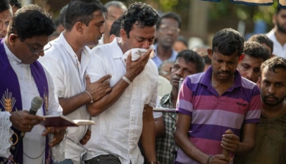 Sudesh Kolonne weeps at the graveside of his wife Manik Suriaaratchi and his 10-year-old daughter Alexendria. (ABC News - Siobhan Heanue)